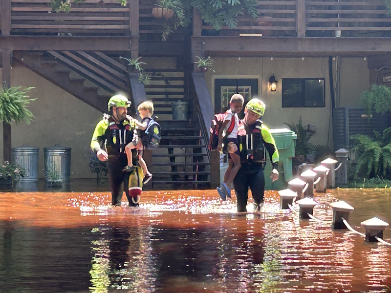 Two CCFD firefighters perform a water rescue of two stranded children off Shad Road.