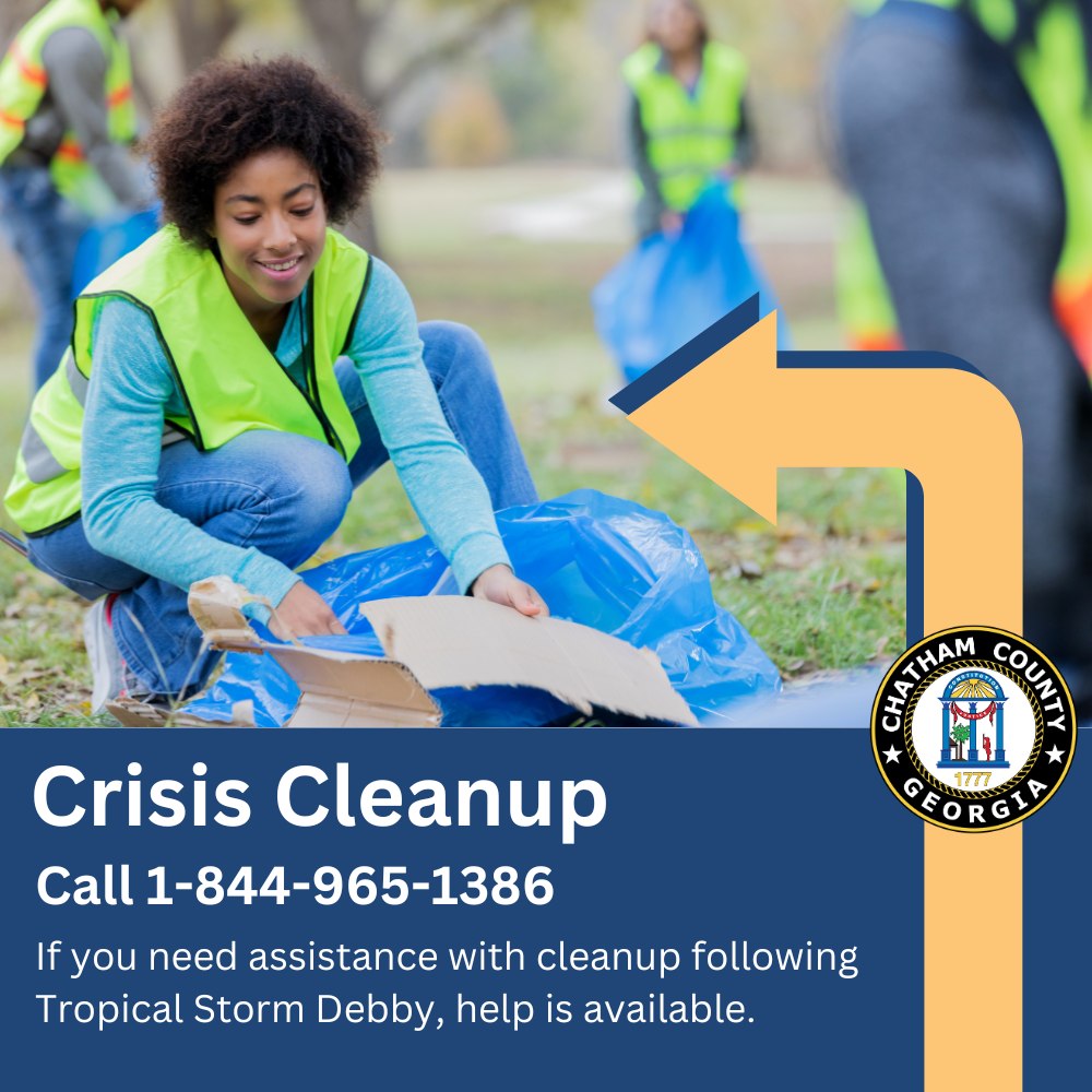 A person wearing a bright safety vest kneels while picking up litter in a park, with other individuals in safety vests visible in the background. The image includes a graphic overlay with text reading "Crisis Cleanup - Call 1-844-965-1386. If you need assistance with cleanup following Tropical Storm Debby, help is available." and features the logo of Chatham County, Georgia.