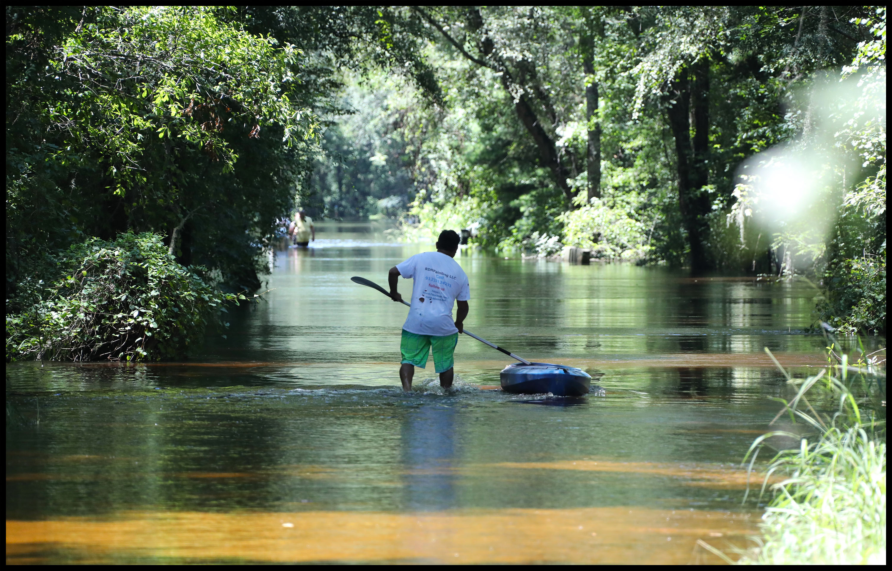 A person walking in a flooded areaDescription automatically generated with low confidence