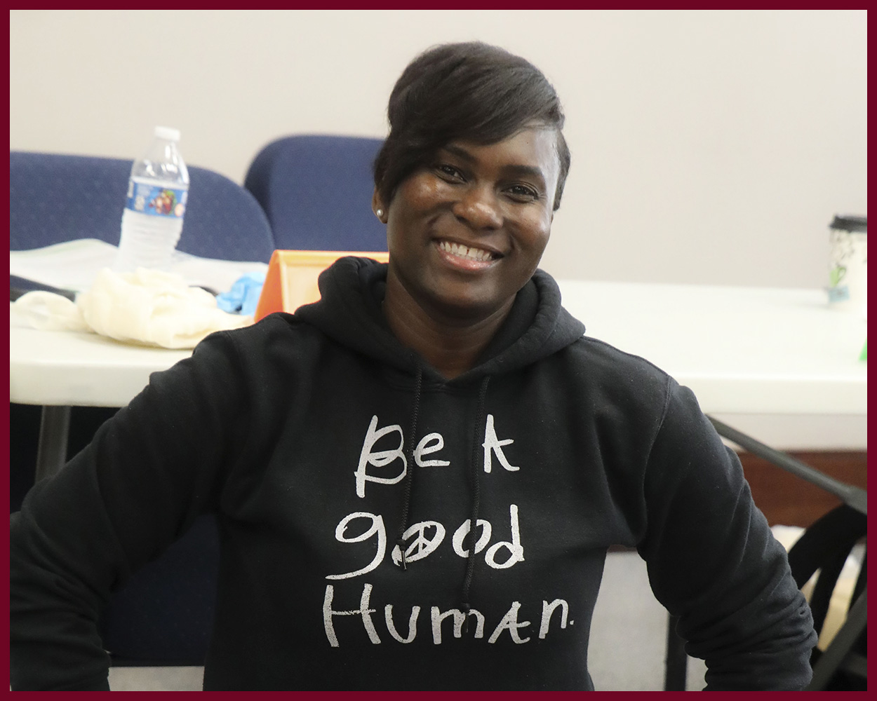 Team Chatham member wearing a shirt reading "Be A Good Human" smiles during CPR training